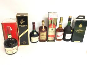 A collection of bottles including Courvoisier, Ama