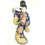 A large Japanese figure of a woman dressed in a ki