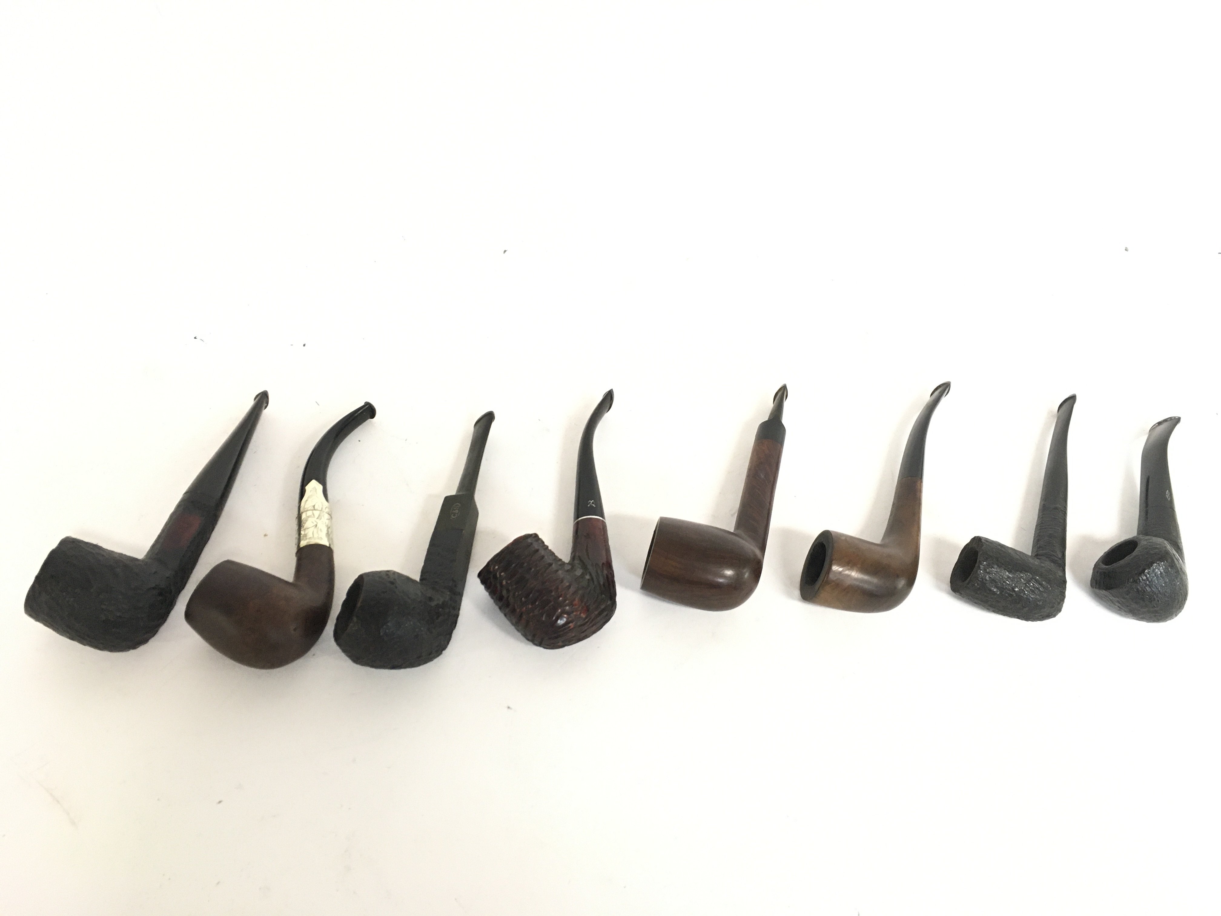 A collection of vintage smoking pipes one with a s