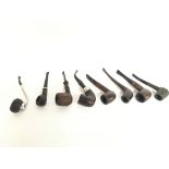 A collection of vintage smoking pipes including a