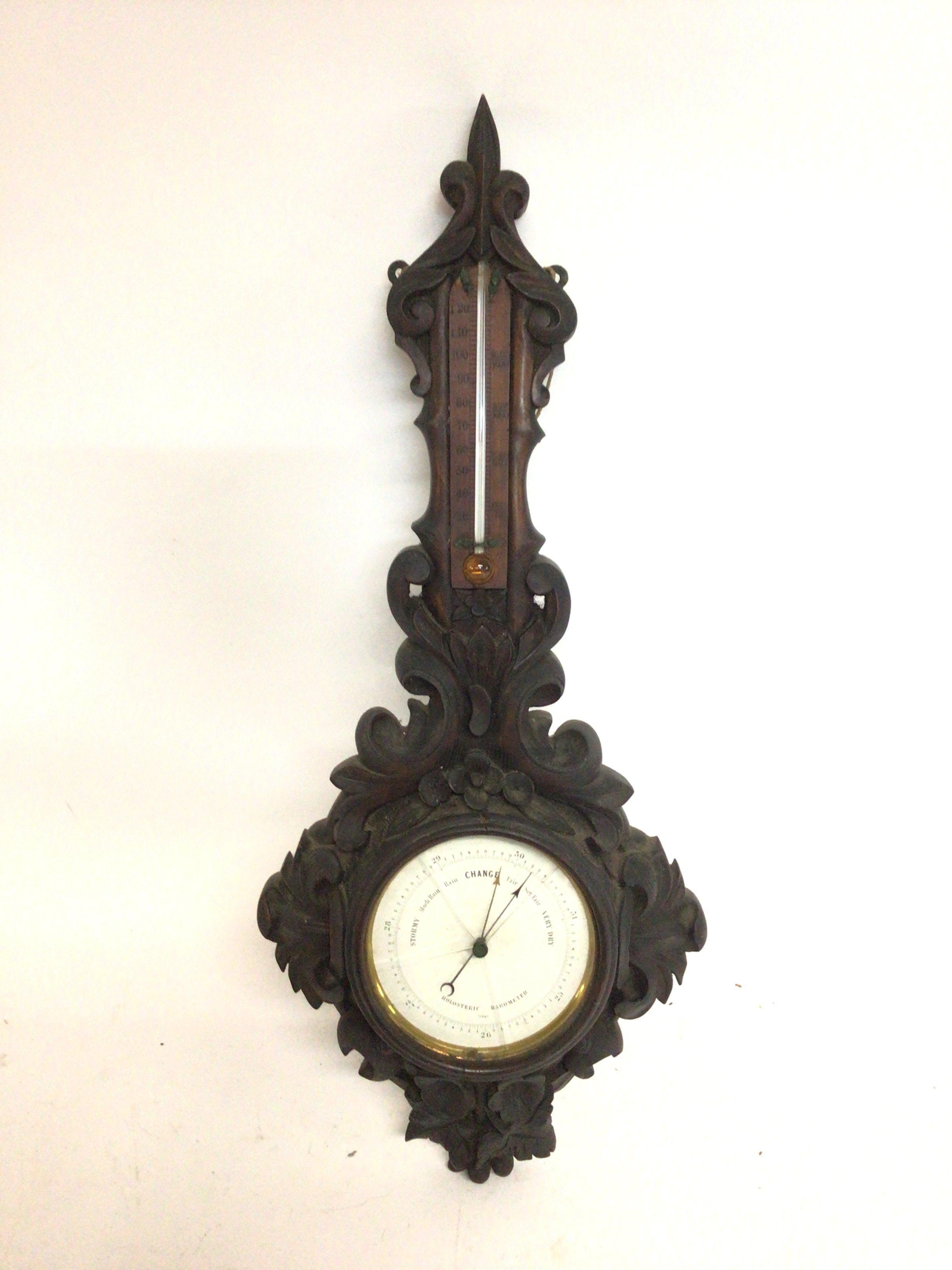 A carved wooden barometer. 58cm tall. This lot can