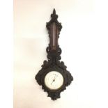 A carved wooden barometer. 58cm tall. This lot can