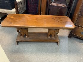 A carved hardwood table the pillars in the form of