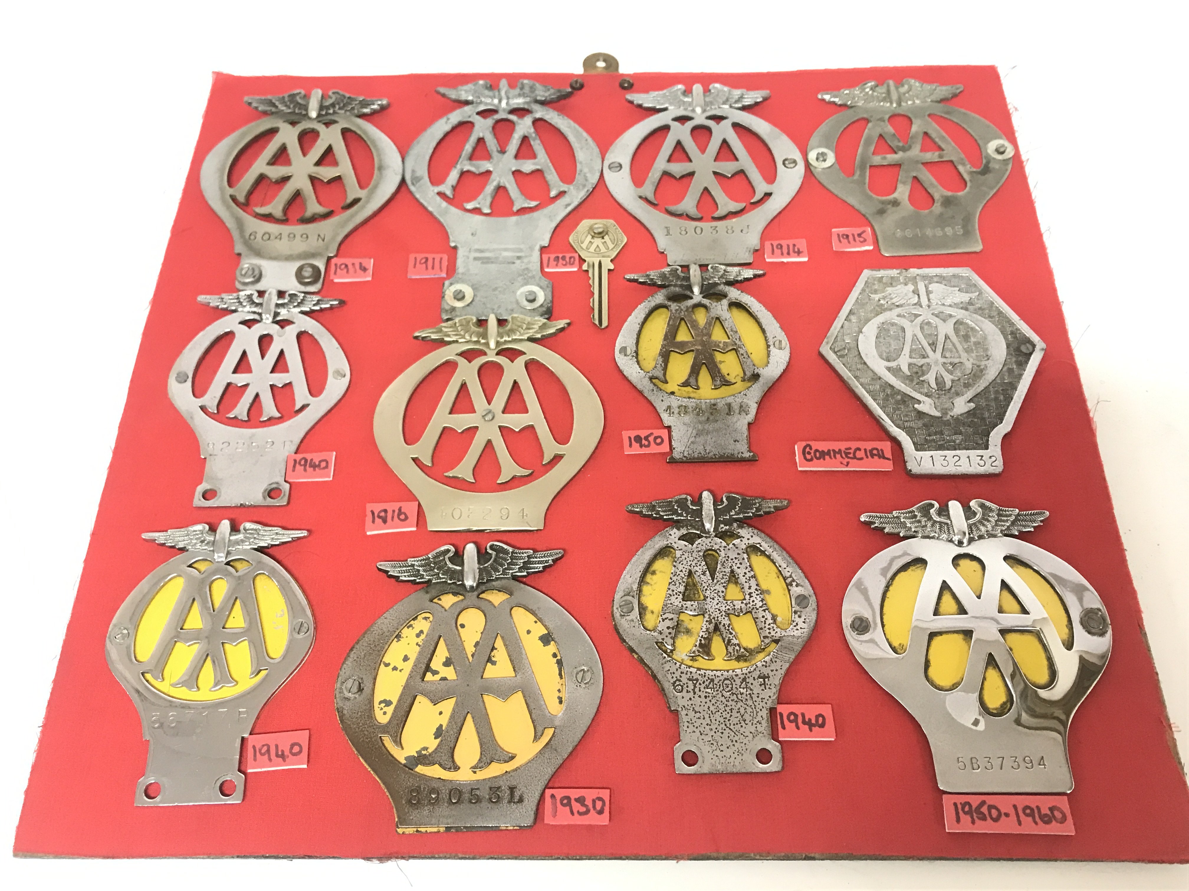 A mounted collection of twelve vintage AA badges f