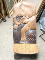 A carved wooden African birthing chair with an ele