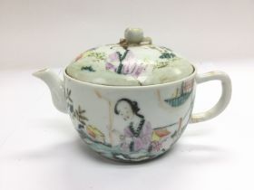 A small teapot wit hand painted decoration of a ge