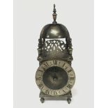 A vintage brass lantern clock with a windup French