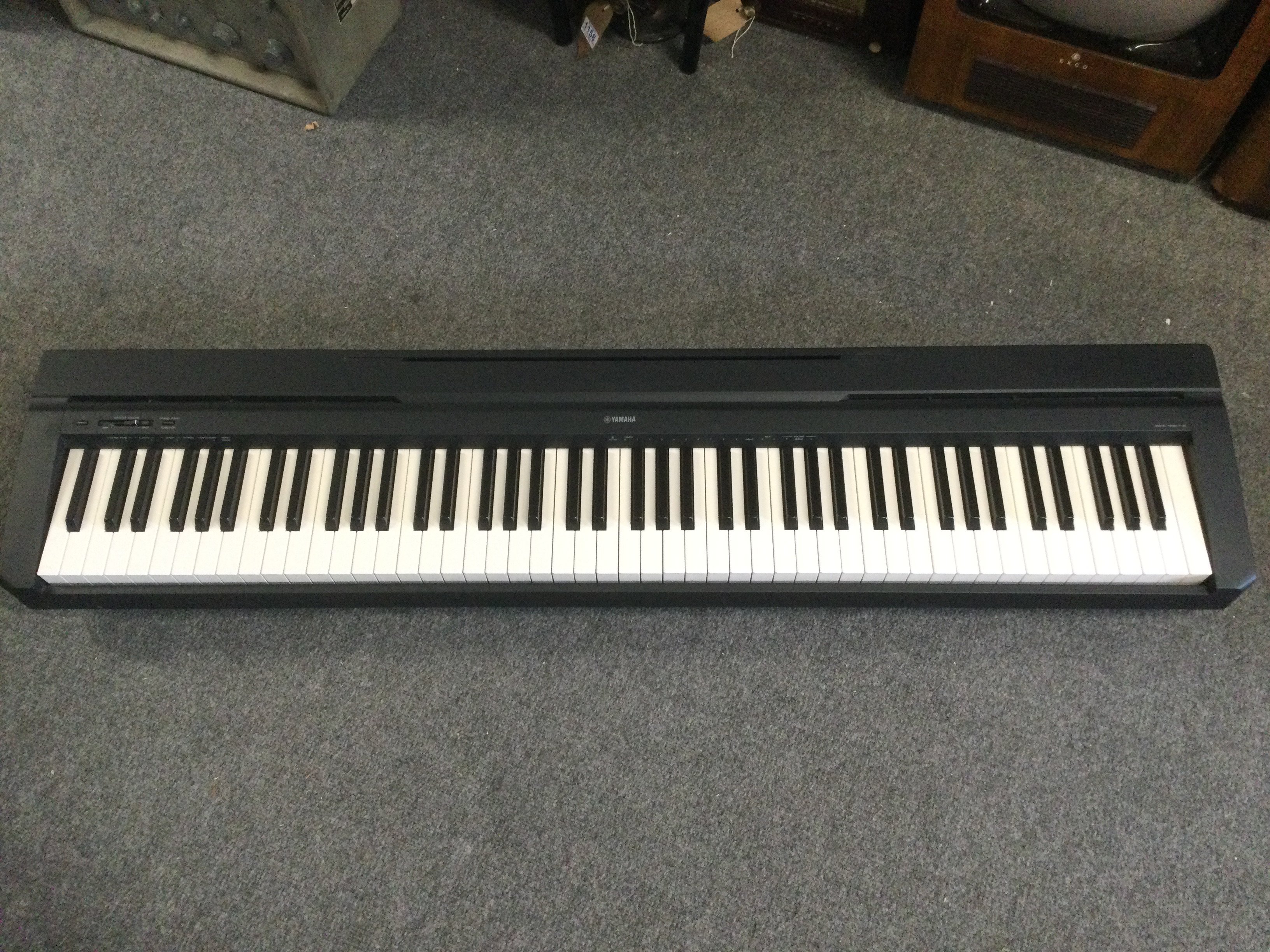 A Yamaha P45 keyboard with expression pedal, power cable and