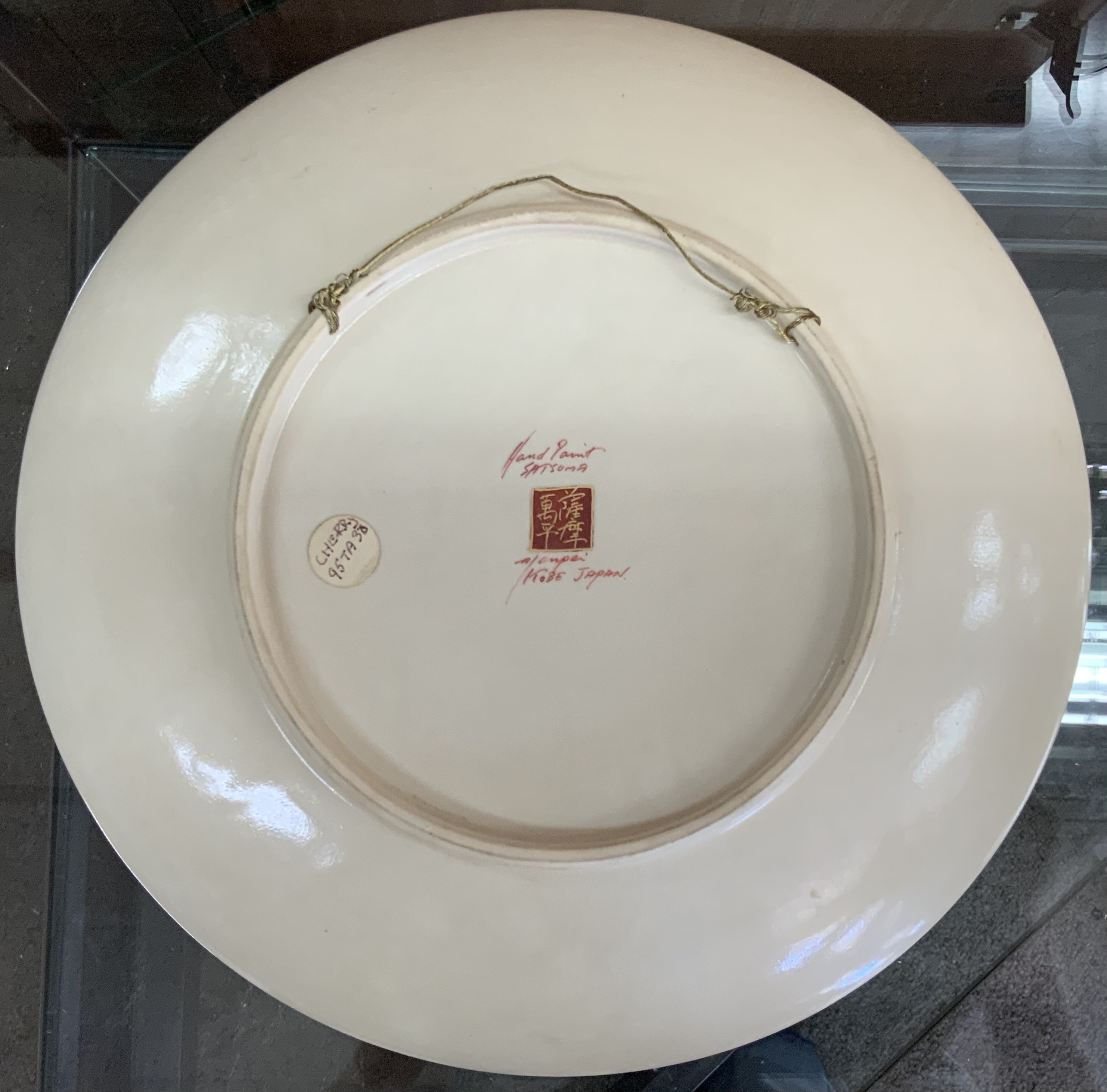 A Japanese Satsuma wall plate, signed to the back. - Image 2 of 2