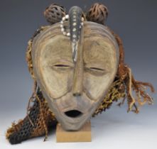 African Cameroon or similar carved wooden mask with horn and bead decoration, on stand, 34cm tall.