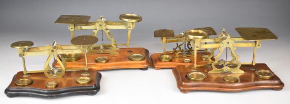 Four sets of brass postage scales, one marked STS, another with rates to pan, length of longest