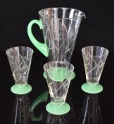 A retro green and clear glass lemonade set comprising a jug and three glasses with cut decoration of