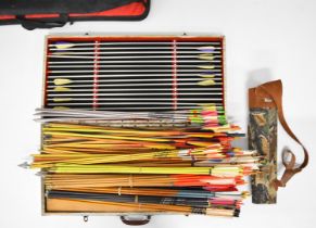 Over 100 archery arrows including aluminum and wooden examples, some in cases.