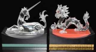 Swarovski Crystal glass dragon and unicorn, both on display plinths, each base 15cm long.