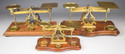Three sets of brass postage scales, two with rates to pans, the other with ivorine plaque to base,