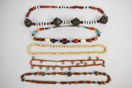 Three tribal glass necklaces, one with agate and white metal beads, one white metal beads and the