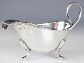 George V hallmarked silver sauce boat with shaped edge and raised on three feet, Birmingham 1931,