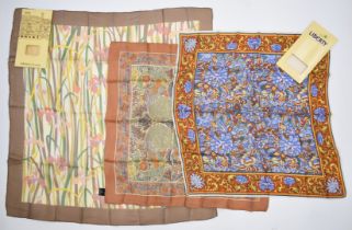 Three Liberty scarves including one with iris decoration, largest 86 x 86cm, with two Liberty card