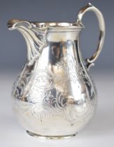 Victorian hallmarked silver milk or cream jug with engraved decoration and scroll handle, London