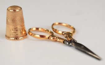 A 9ct rose gold thimble (3.4g) and matching scissors