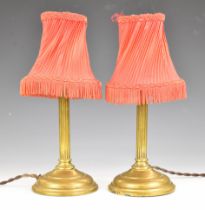 Two brass reeded column table lamps with red shades to clip onto the bulbs, height of bases 30cm