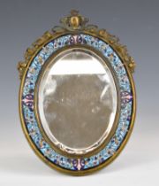 A 19thC brass and champlevé enamel easel back bevelled glass mirror with ornate surmount, 23 x 16cm