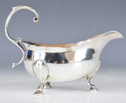 Georgian hallmarked silver sauce boat with shaped edge, scroll handle and raised on three feet,