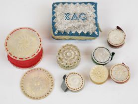 A collection of needlework pin cushions with mother of pearl and beaded decoration, one dated