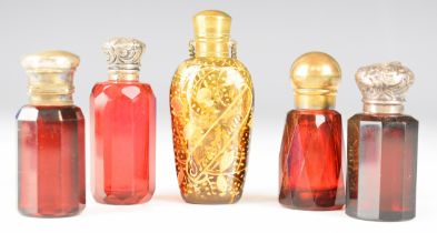 Five 19th / 20thC cranberry / ruby glass scent / perfume bottles some with hallmarked silver mounts,