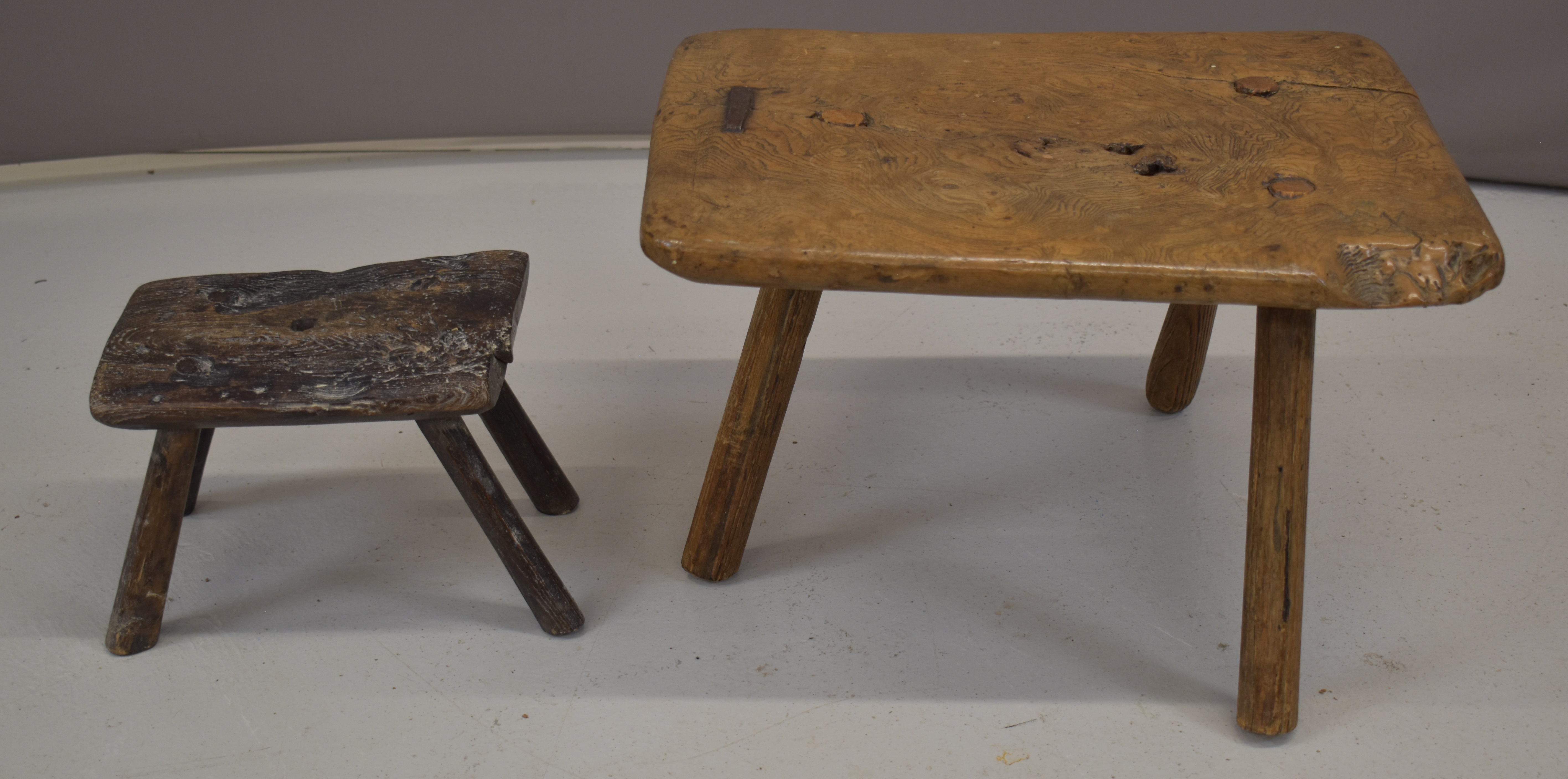 Two 17th / 18thC elm milking stools with iron staples, largest W44 x D38 x H28cm