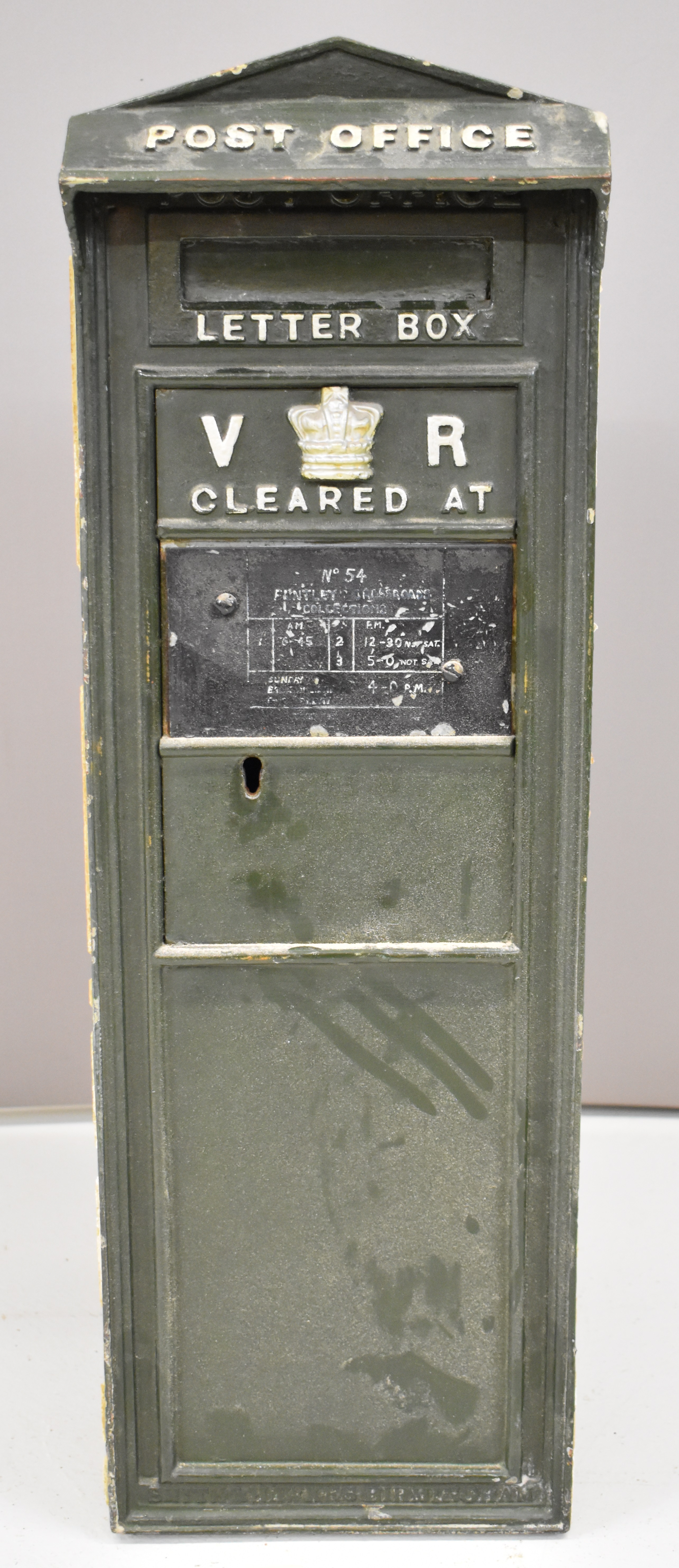 Victorian WB75 cast iron wall mounted letter box with VR cypher and crown to door, below a peaked