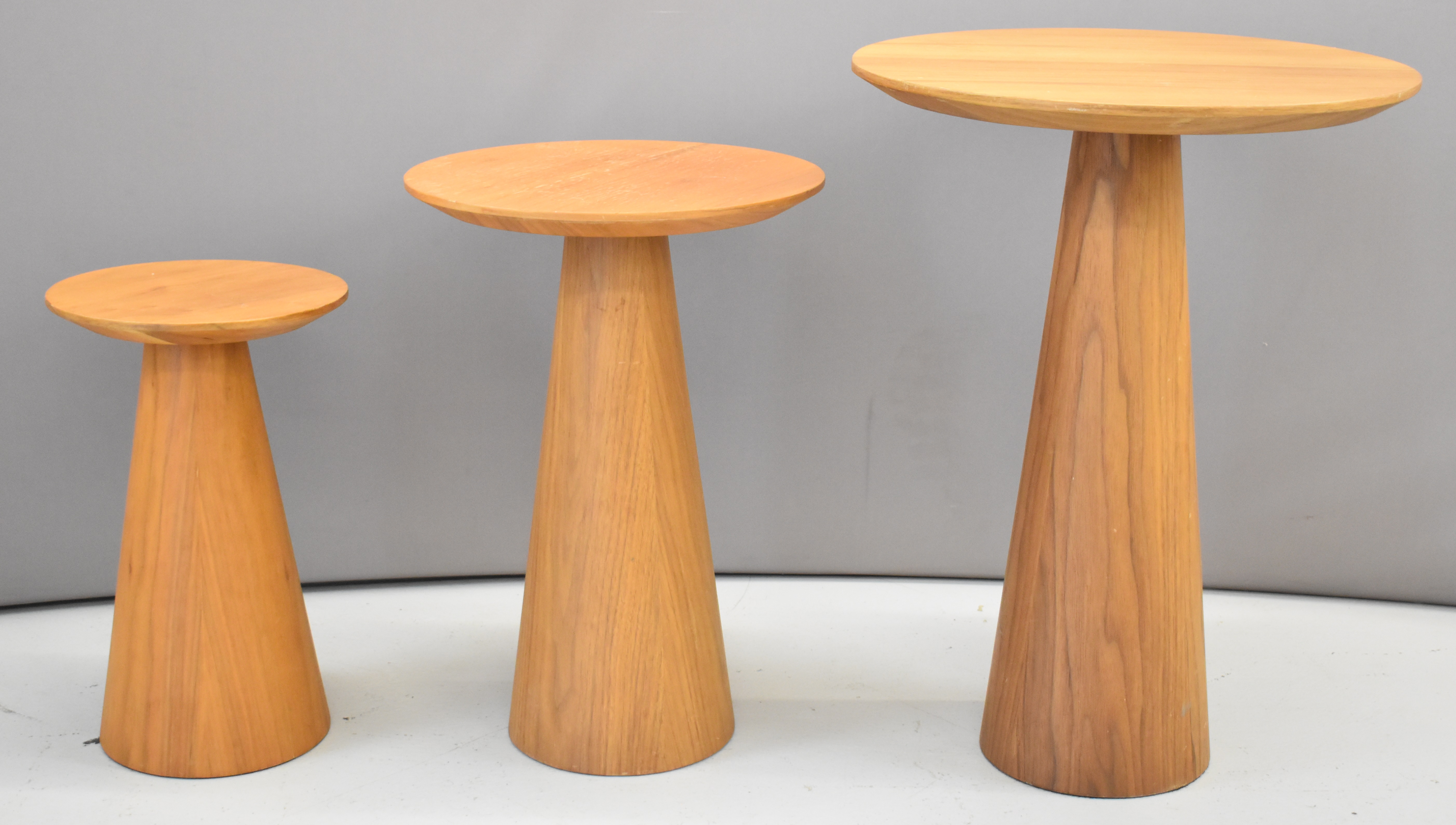 Set of three graduated mid century modern circular occasional tables with solid tapering supports,