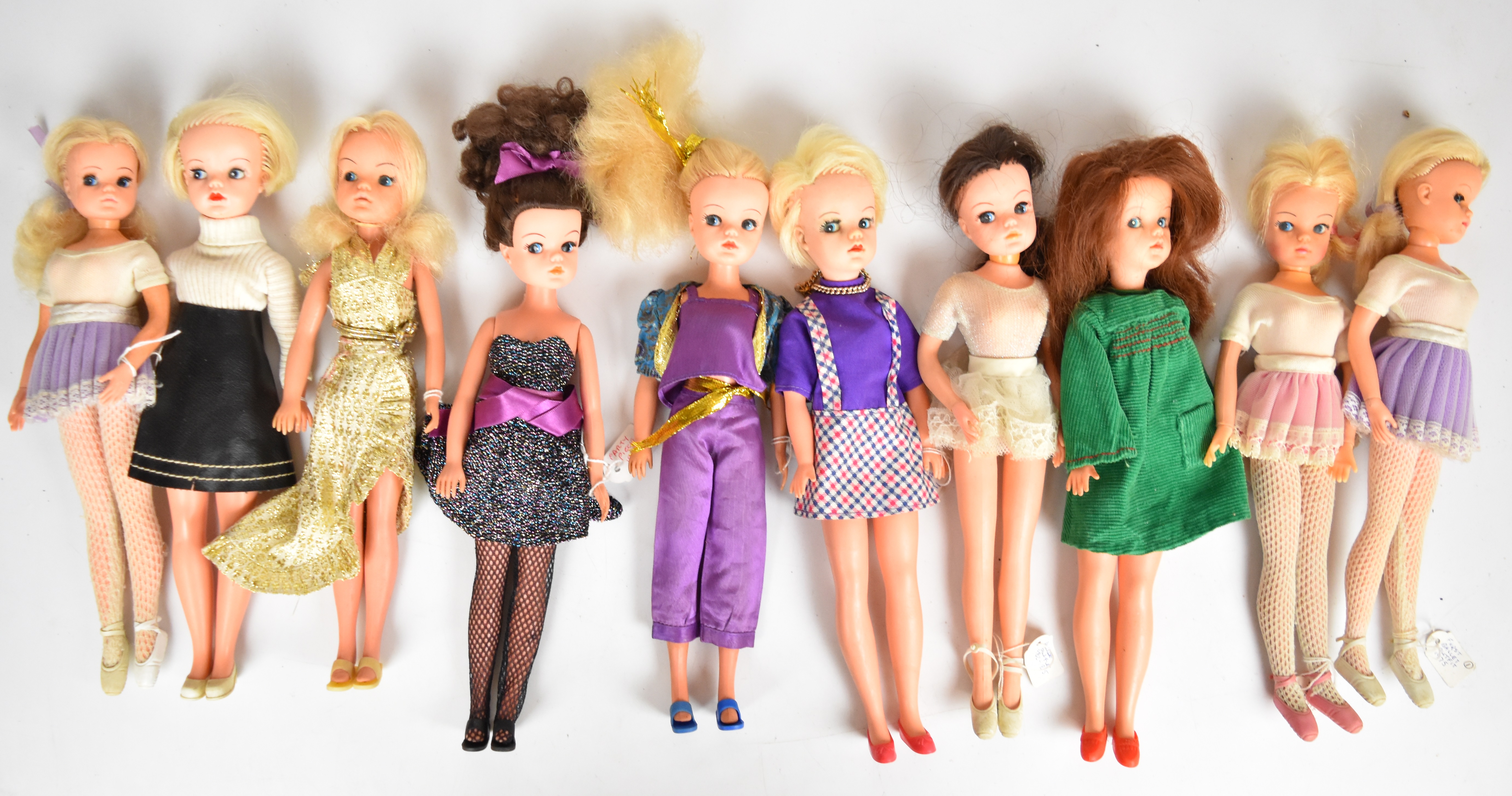 Ten vintage Sindy dolls by Pedigree dressed in clothing ranging from the 1960's to 80's.