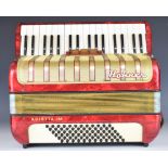 Hohner Arietta IM 36 key piano accordion in red and gold, with leather strap and hard carry case.