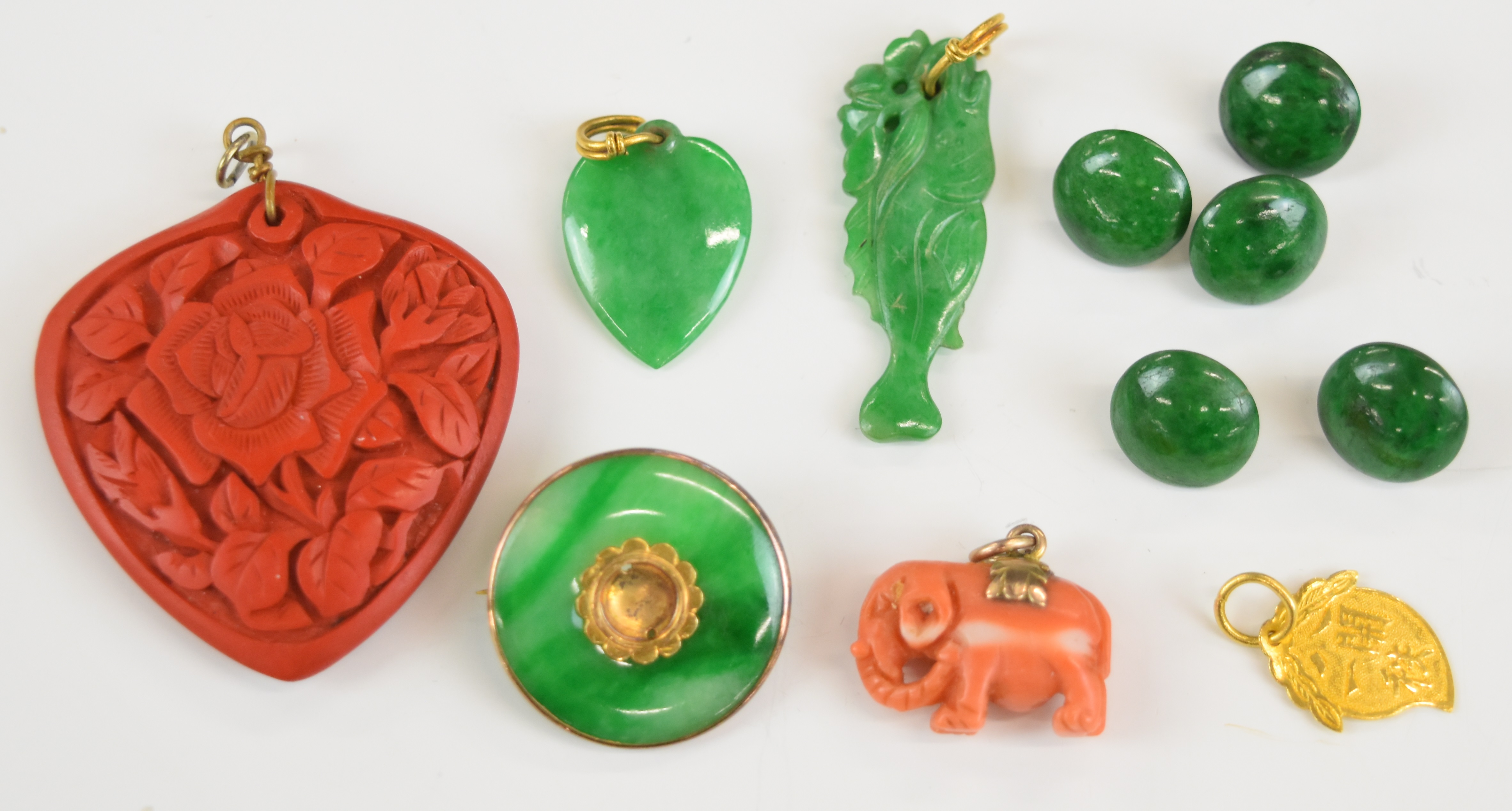A yellow metal pendant (tests as 18k, 1g), two jadeite pendants one carved in the form of a fish and