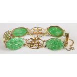 A 9k gold Chinese bracelet set with carved jadeite panels and pierced character links, 12.1g