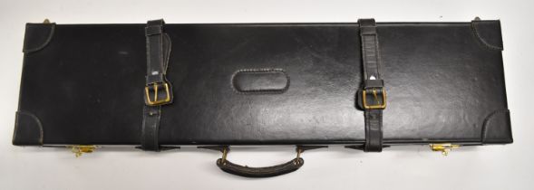 Black leather shotgun case with fitted interior and code locks, 82.5 x 21 x 11cm.
