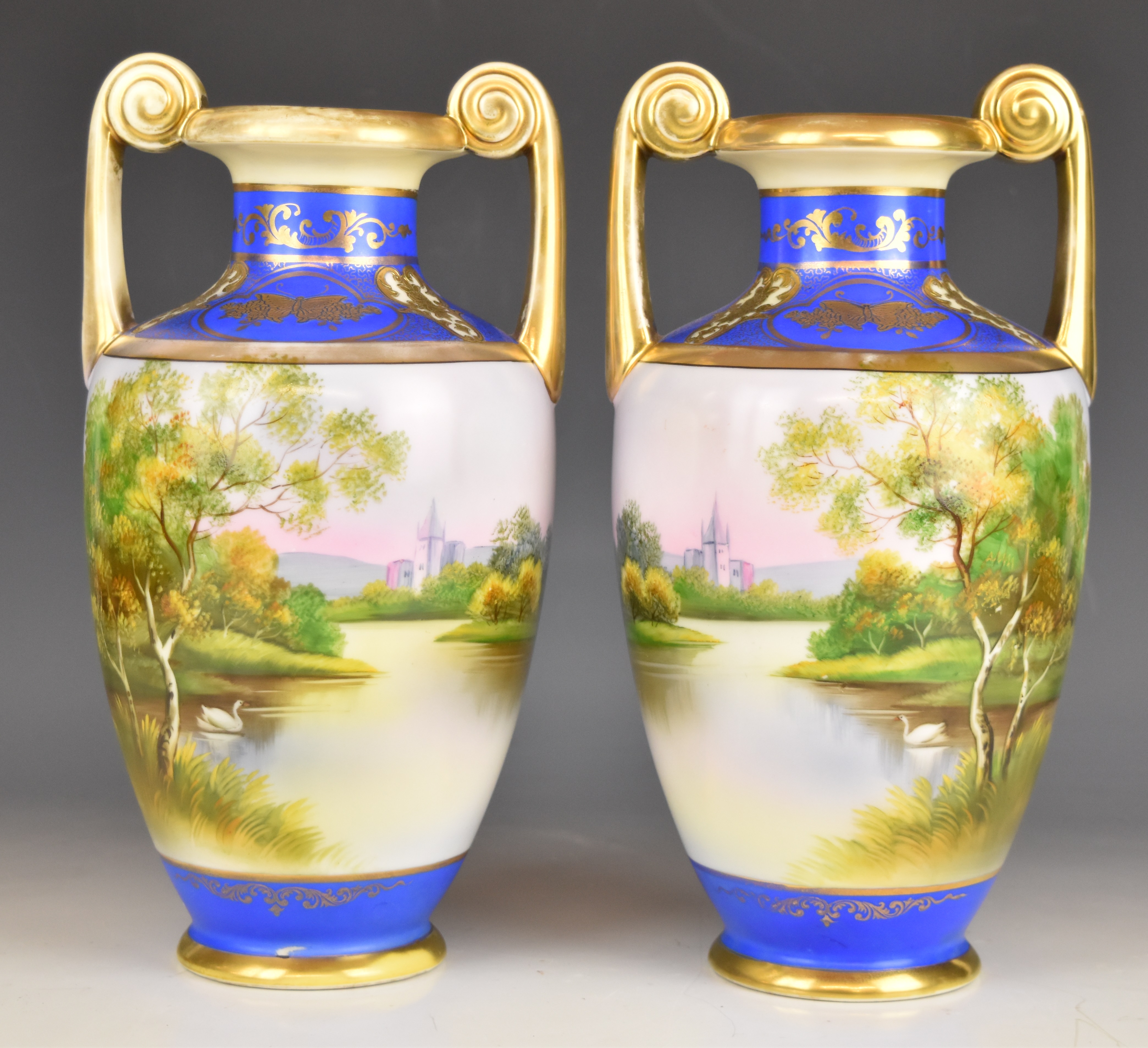Noritake pair of twin handled pedestal urn shaped vases with pastoral decoration, height 30cm