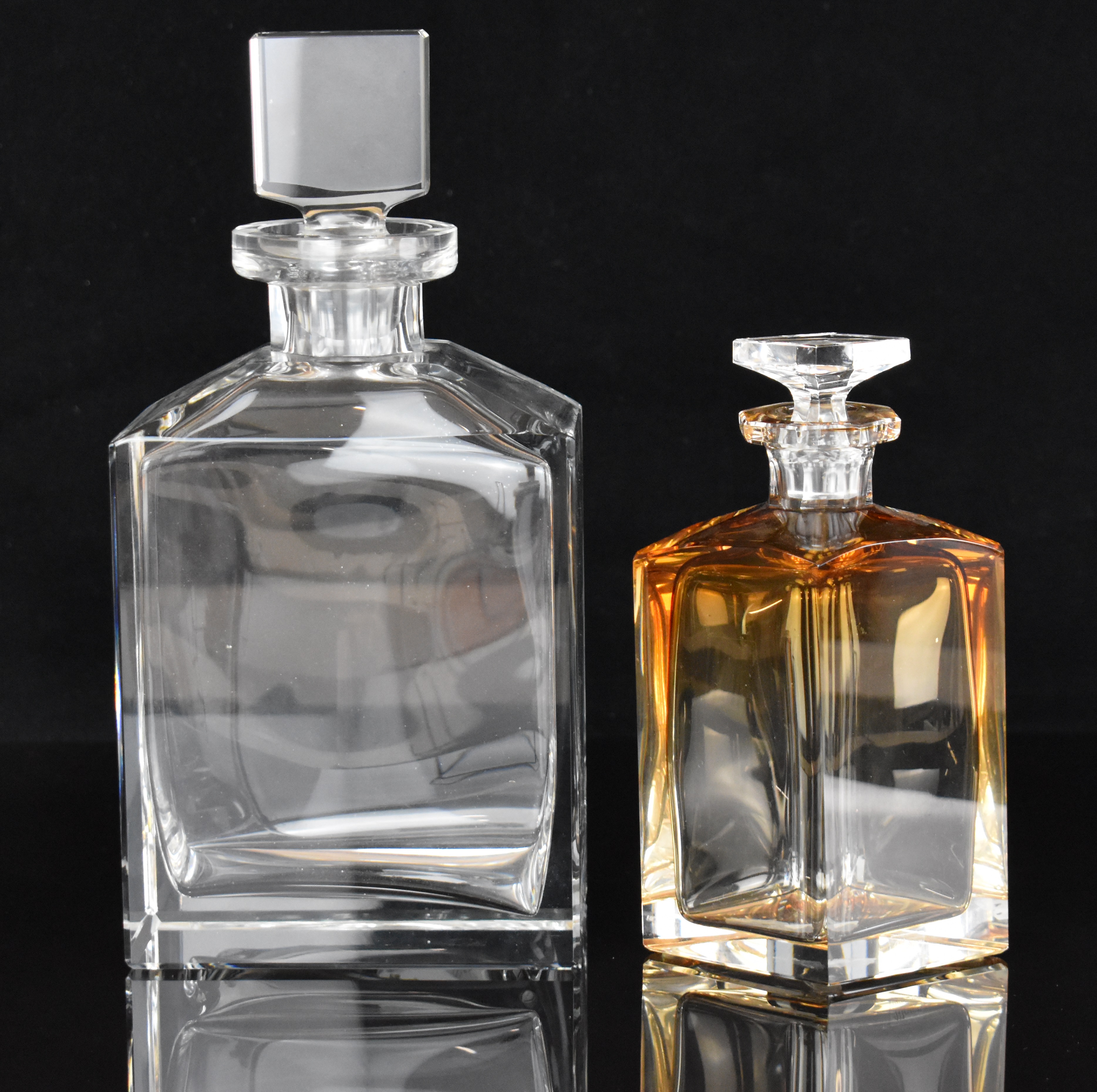 Two glass decanters, one Moser with graduated amber to clear design, signed to base, the other of