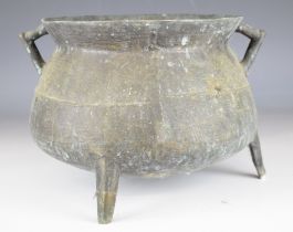 Chinese bronze twin handled cauldron raised on three legs, 46cm in diameter.