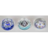 Three Whitefriars or similar millefiori glass paperweights, two with faceted decoration, largest