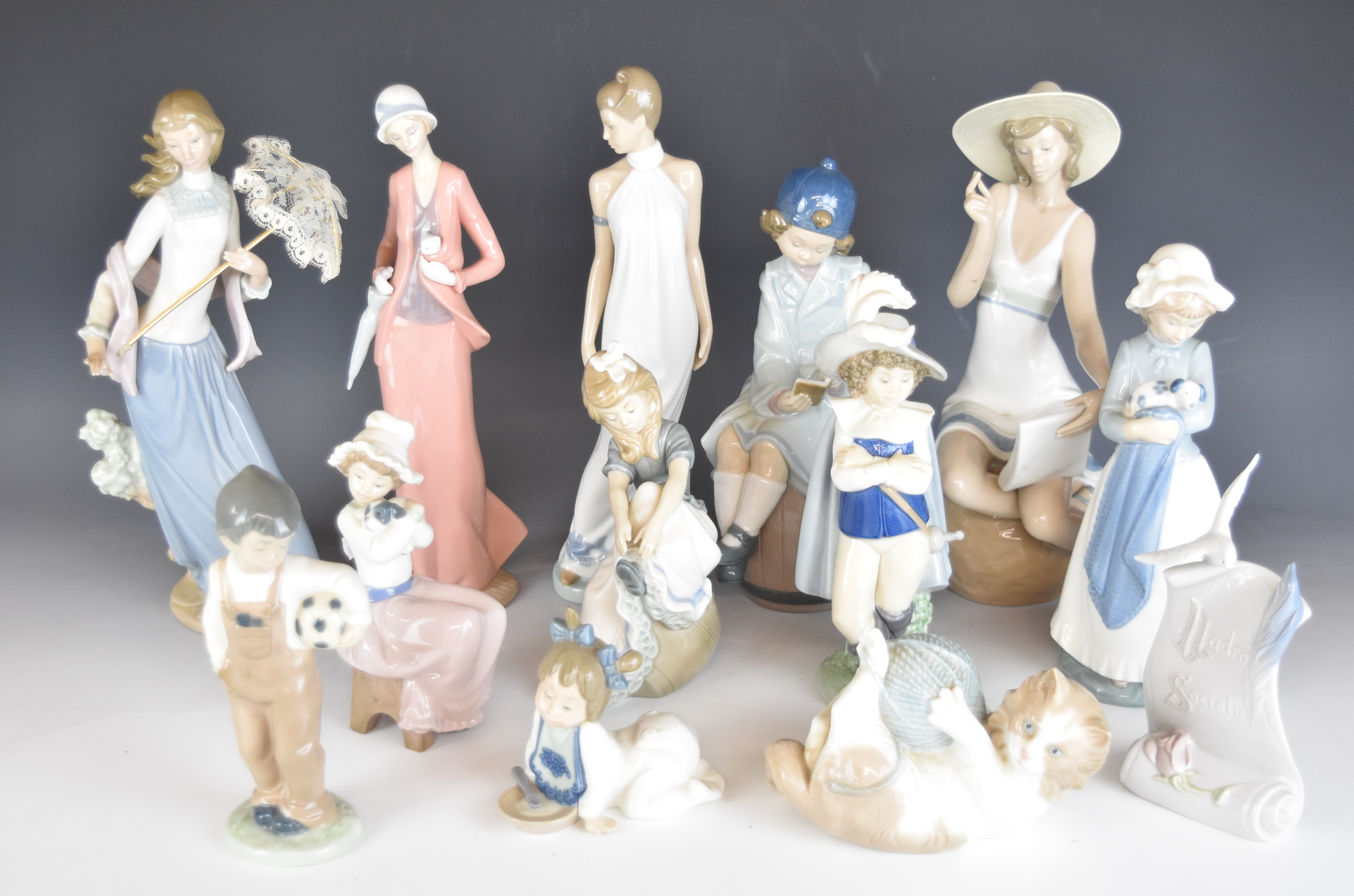 A collection of Lladro and Nao figurines and an advertising stand, tallest 32cm