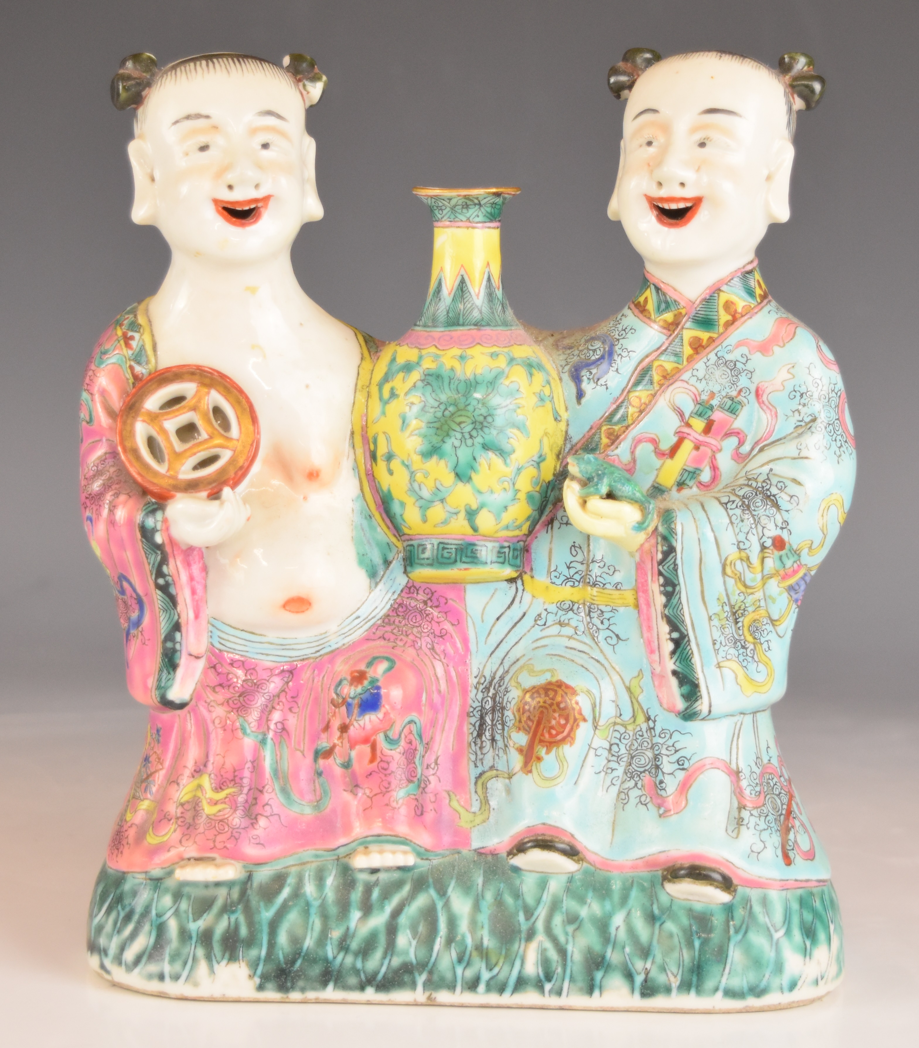 Chinese figural group holding a toad and a bi-disc, either side of an imperial style vase, height