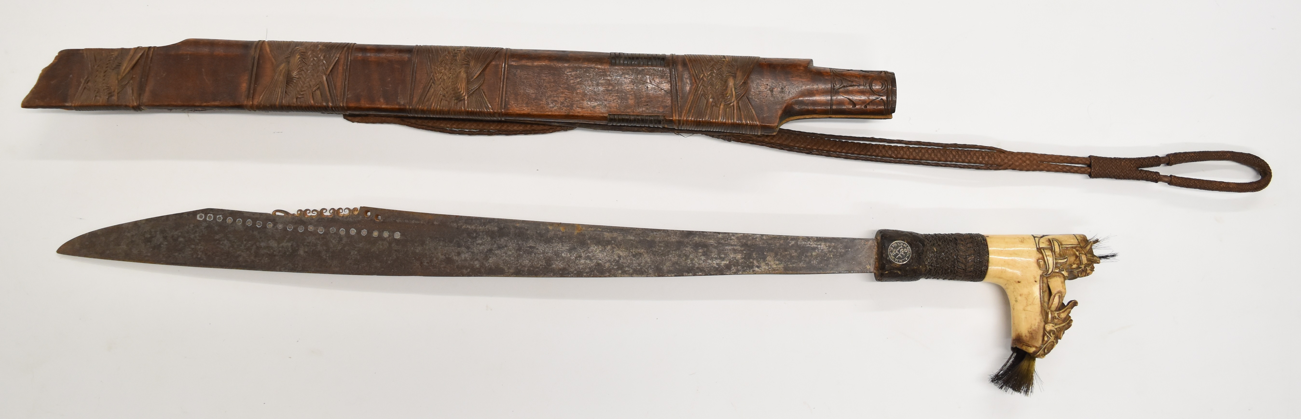 Borneo Dayak headhunter's sword with heavily carved bone hilt, hair plumes, coin inset grip,