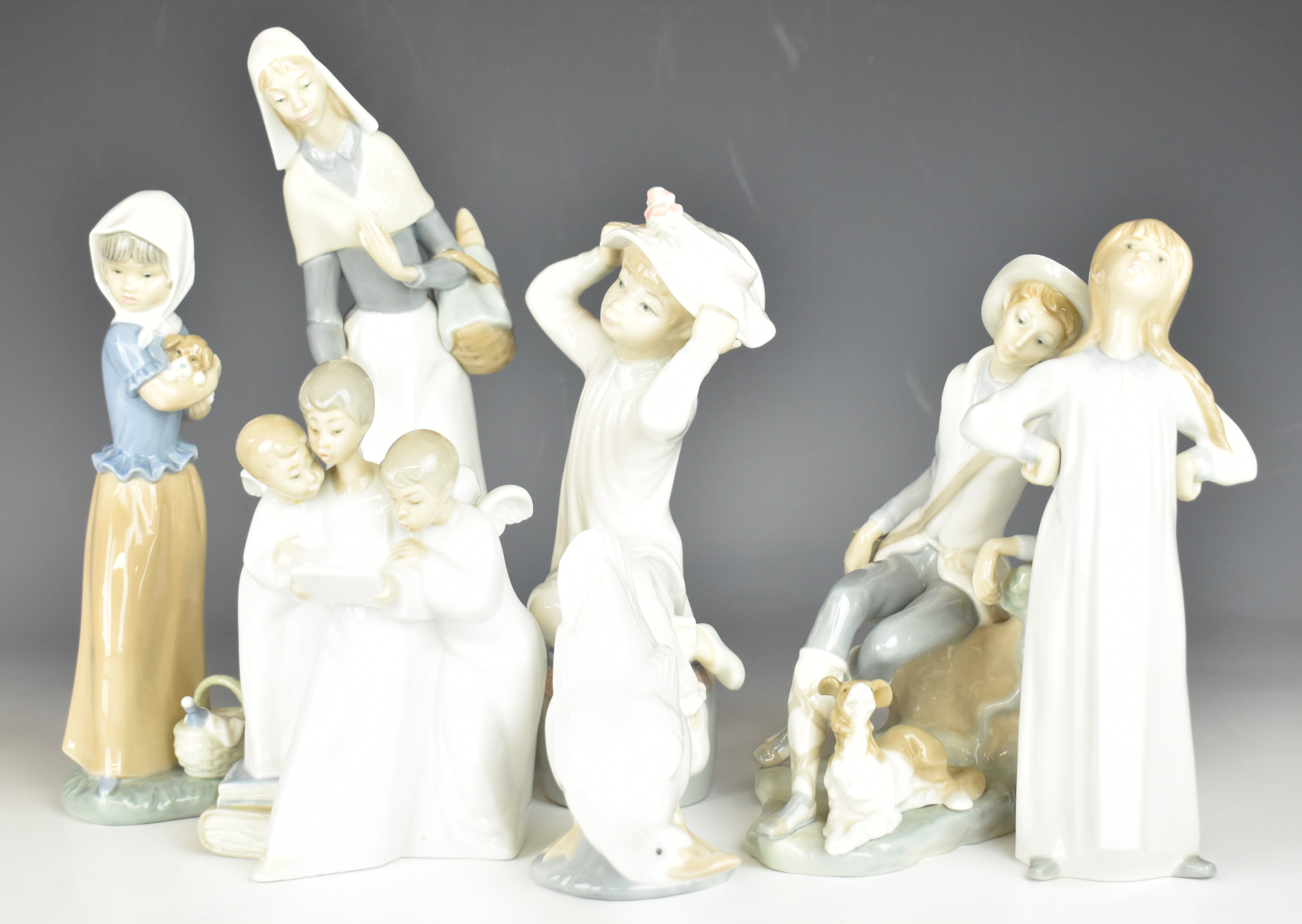 Collection of Lladro / Nao figures, the four largest Lladro includes lady with dog, tallest 28cm