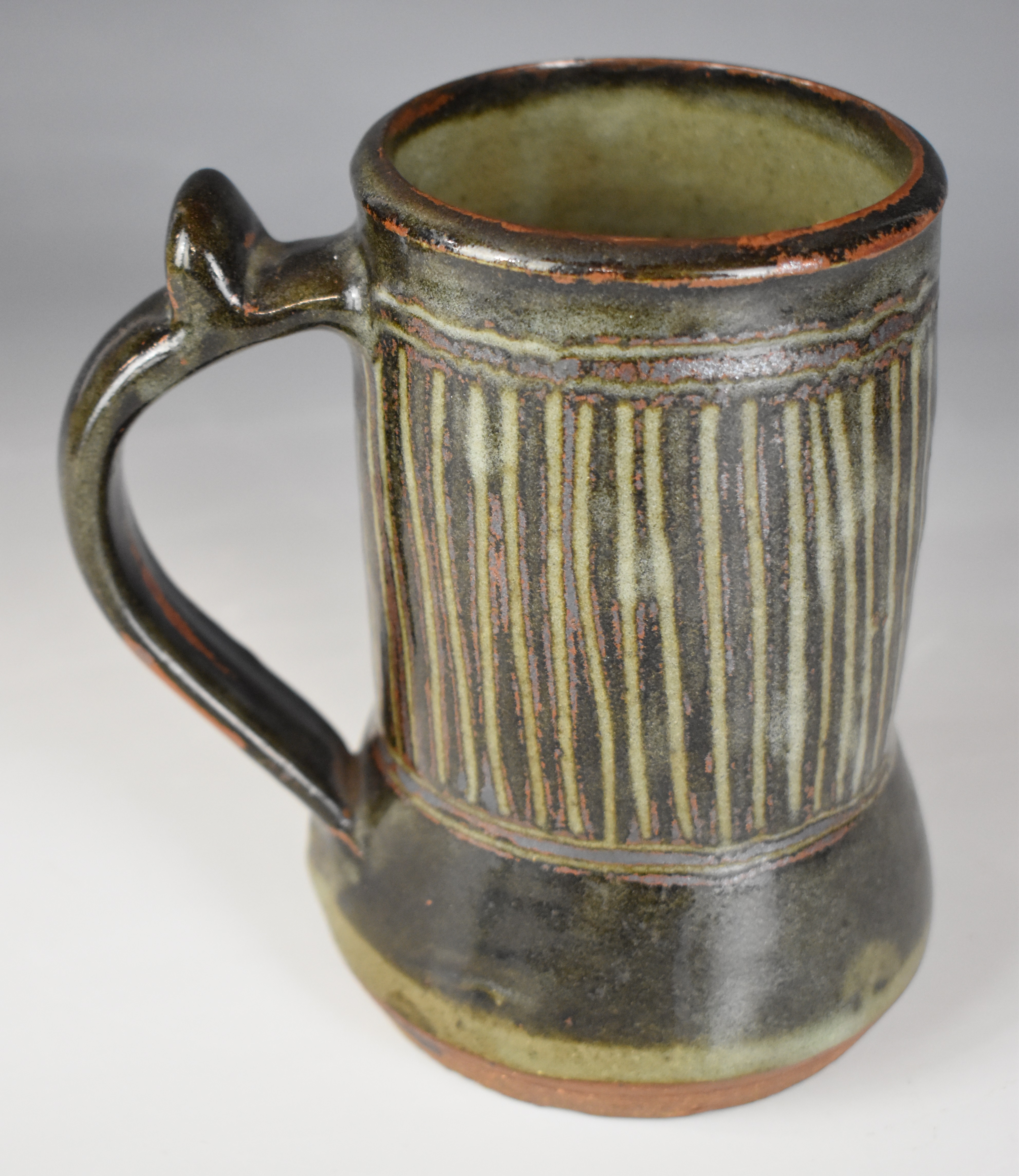 Ladi Kwali (Nigerian 1925-1984) studio pottery tenmoku glazed tankard with artist's seal, height