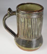 Ladi Kwali (Nigerian 1925-1984) studio pottery tenmoku glazed tankard with artist's seal, height