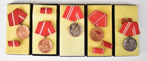 Five East German medals including Long Service examples, all in cases