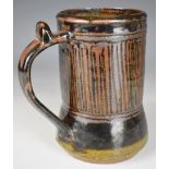 Ladi Kwali (Nigerian 1925-1984) studio pottery tenmoku glazed tankard with artist's seal, height