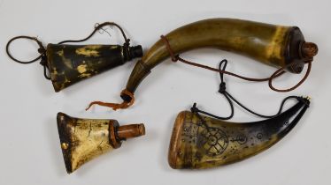 Four horn powder flasks with wooden fittings, one with carved decoration, largest 30cm long.